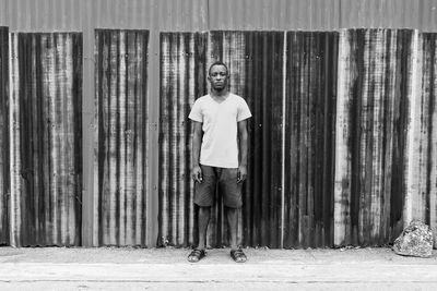 Portrait of man standing against wooden wall