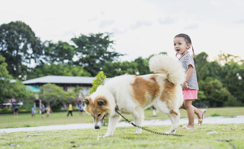 Side view of man with dogs on field