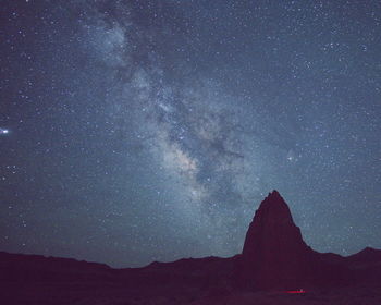 Low angle view of silhouette mountain against sky at night