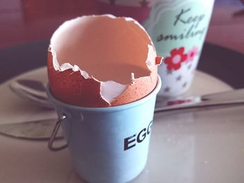 Close-up of broken eggshell in container on table