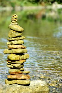 Close-up of stack of logs in calm lake