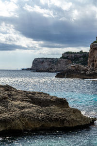 Rock formations on sea shore against sky