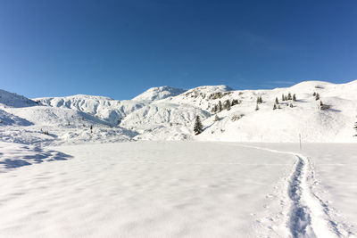 Scenic view of snowcapped mountains against clear blue sky