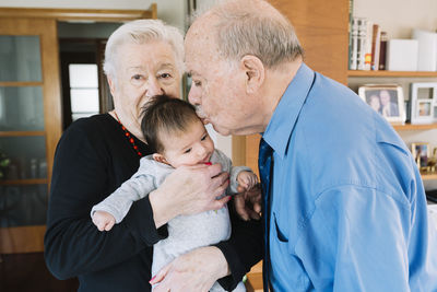 Great-grandparents with baby at home