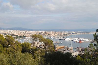 Aerial view of city against cloudy sky