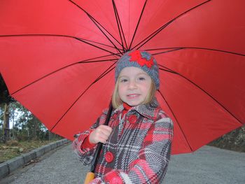 Portrait of smiling young woman holding umbrella