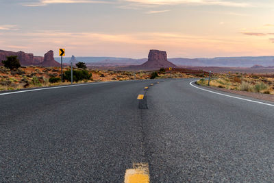 Road amidst mountains against sky during sunset