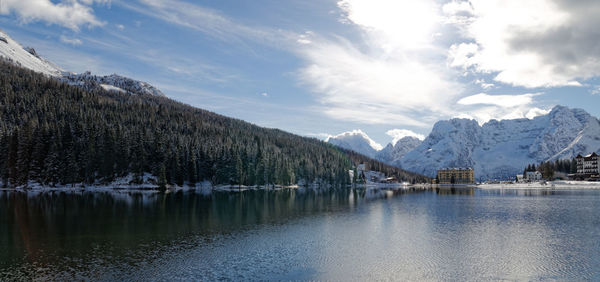 Scenic view of lake by snowcapped mountains against sky