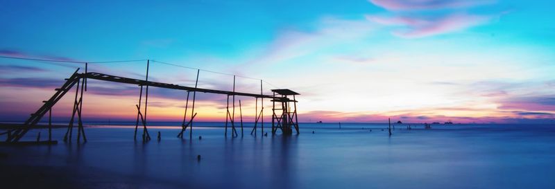 Silhouette beach against sky during sunset