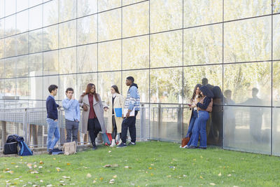 Multiracial students discussing by building on university campus