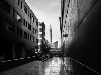 Empty canal amidst buildings against sky in city