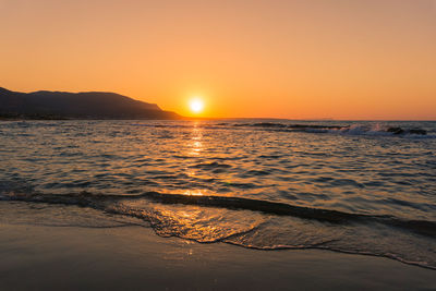 Scenic view of sea against orange sky