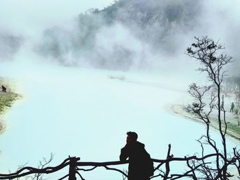 Man standing by plants against trees