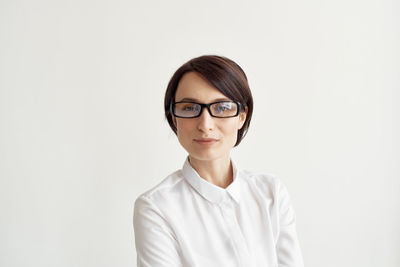 Portrait of smiling young woman against white background