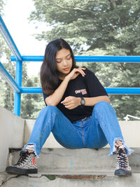 Full length of woman sitting on steps