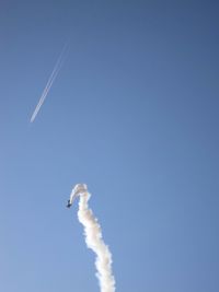 Low angle view of airplane flying against clear blue sky