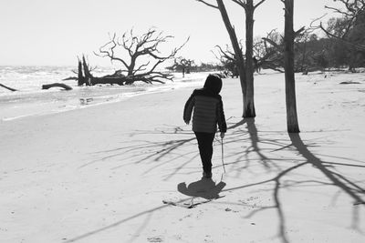 Rear view of man walking on beach