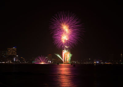 Firework display over city at night