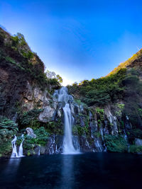 Scenic view of waterfall against sky