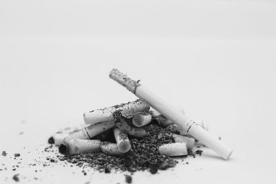 Close-up of cigarette smoking against white background