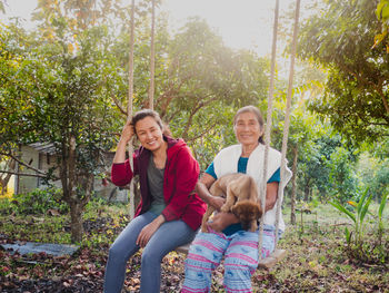 Portrait of smiling women sitting on swing