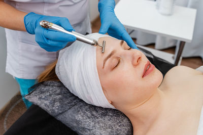 Woman in spa having a facial treatment. equipment for skincare.