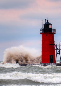 Lighthouse by sea against sky