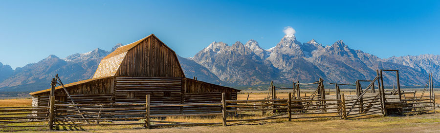 Built structure on field against clear blue sky