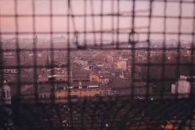 Digital composite image of cityscape against sky seen through glass window