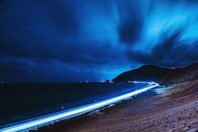 Scenic view of sea against dramatic sky at night