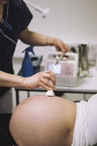 Hands of gynecologist doing ultrasound of pregnant woman in hospital