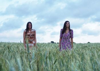 Women standing on field against sky