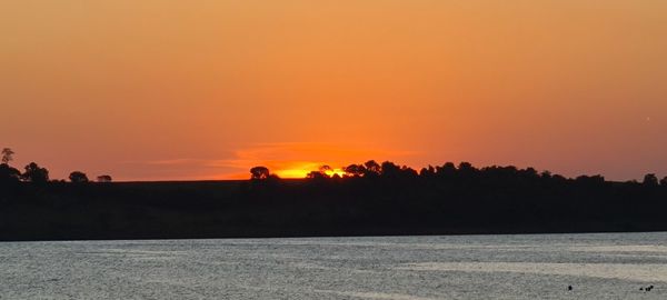 Scenic view of sea against orange sky