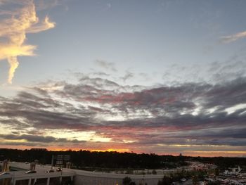 Houses against dramatic sky during sunset