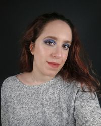 Portrait of woman against black background