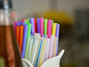 Close-up of colored plastic tubes in a cup