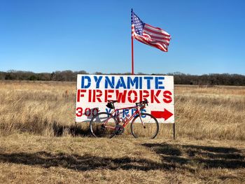 Information sign on field against sky