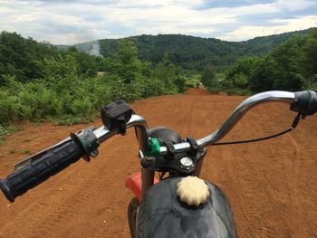 Close-up of horse cart on field against sky