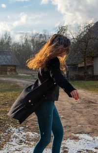 Full length of woman spining around in snow