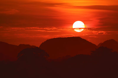 Sunset on night red sky back over silhouette tree mountain