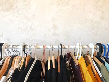 Row of clothes hanging on rack against wall