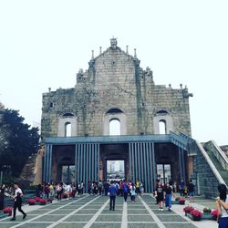 People at cathedral against clear sky