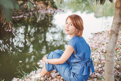 Portrait of woman sitting at lakeshore