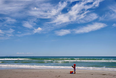 Full length of toddler on deserted beach against sky