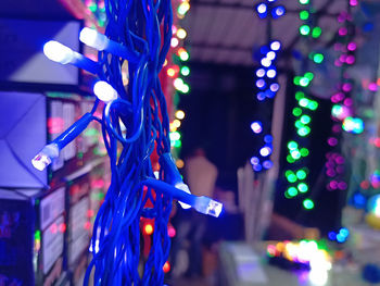 Close-up of illuminated lighting equipment hanging at night