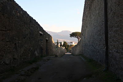 Footpath amidst buildings against sky