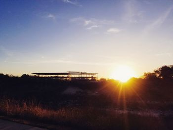 Silhouette trees on landscape against sky during sunset
