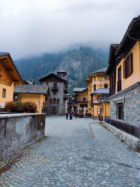 Street amidst buildings in town against sky