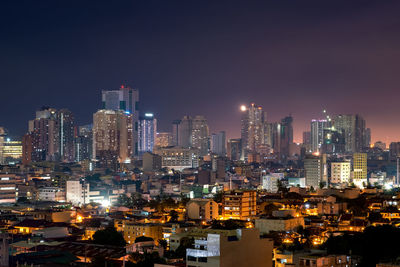 Illuminated cityscape against sky at night