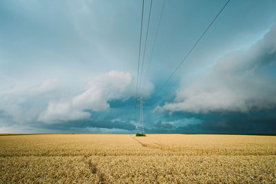 Scenic view of electricity pylon on field against sky